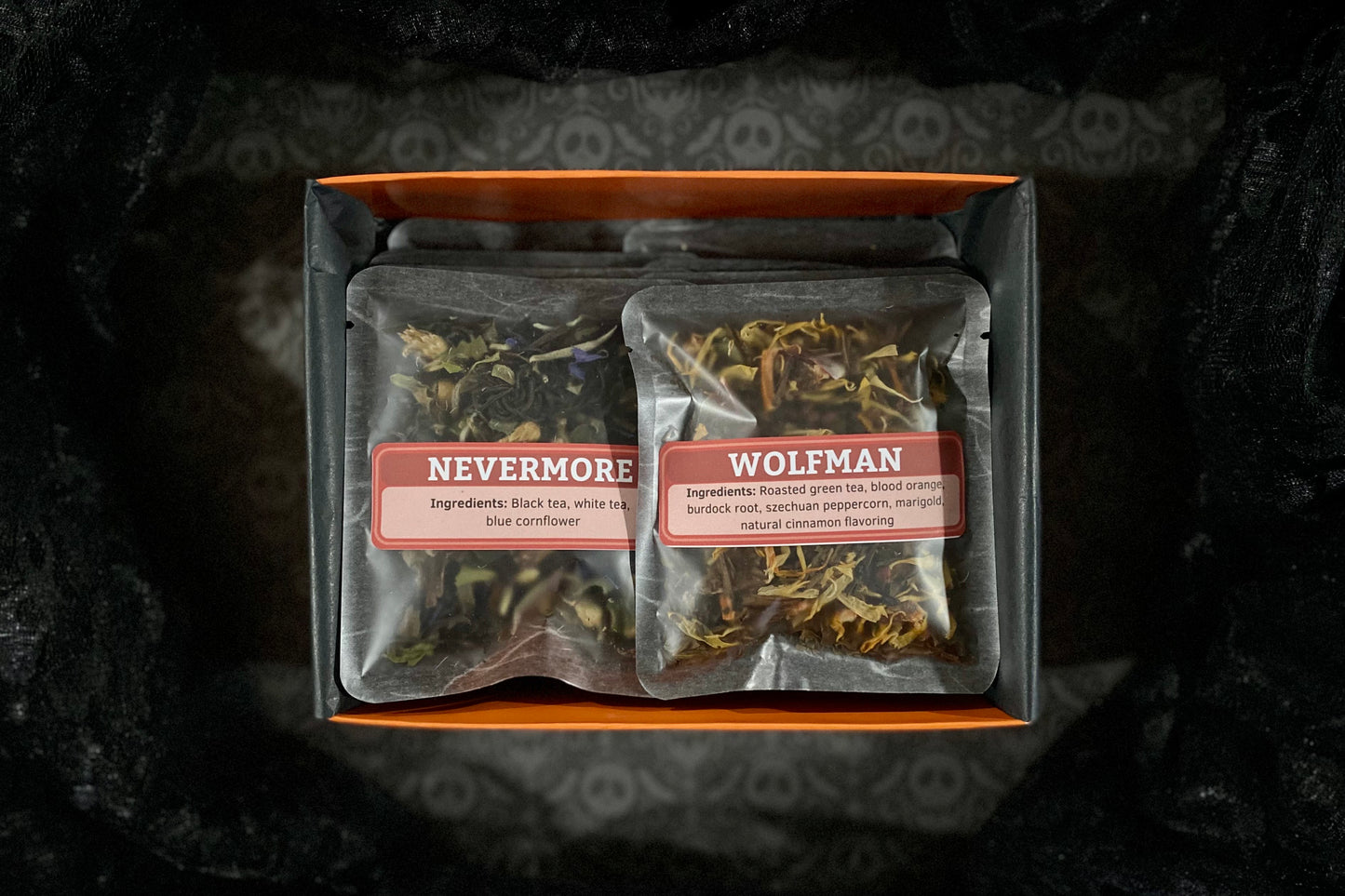 Open orange sampler box on black background with two teas showing: Nevermore & Wolfman
