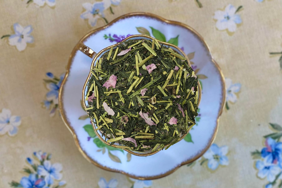 Tea leaves in a teacup with a floral patterned background