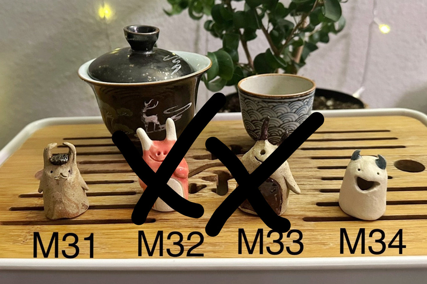 Four slug demon lookin tea pets on a bamboo tea tray