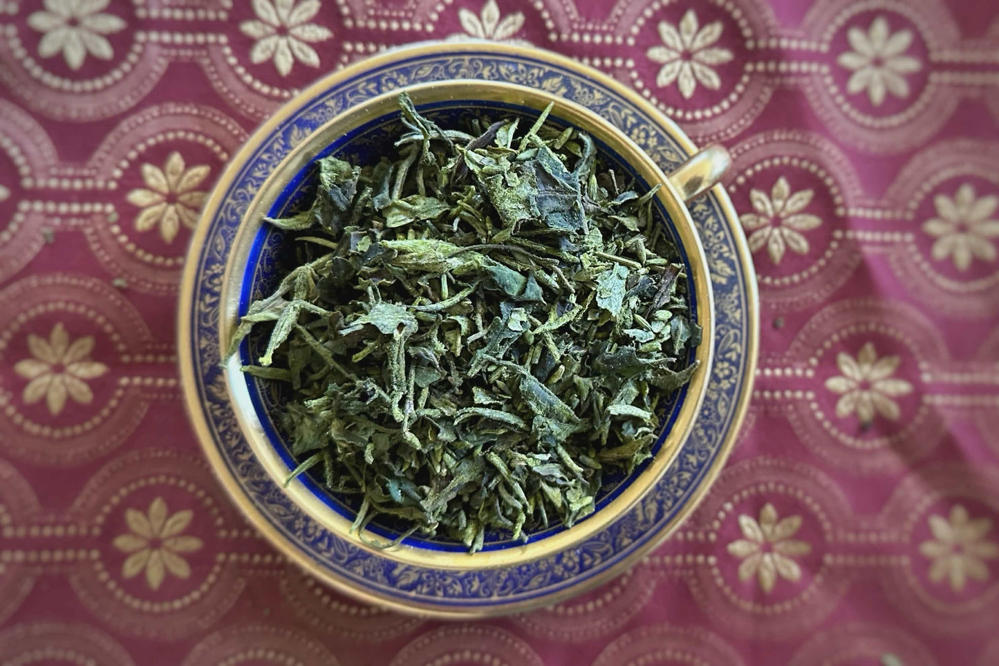 Teacup full of matcha-dusted white tea with lavender