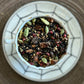 Teacup full of black tea with chai spices and coffee beans on a spiderweb saucer 