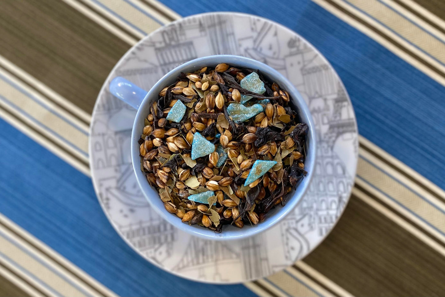 Teacup full of roasted barley, glittery aloe pieces and tea leaf