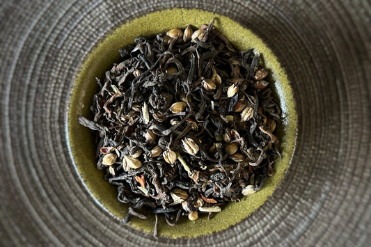 teacup full of tea leaves, barley and spice