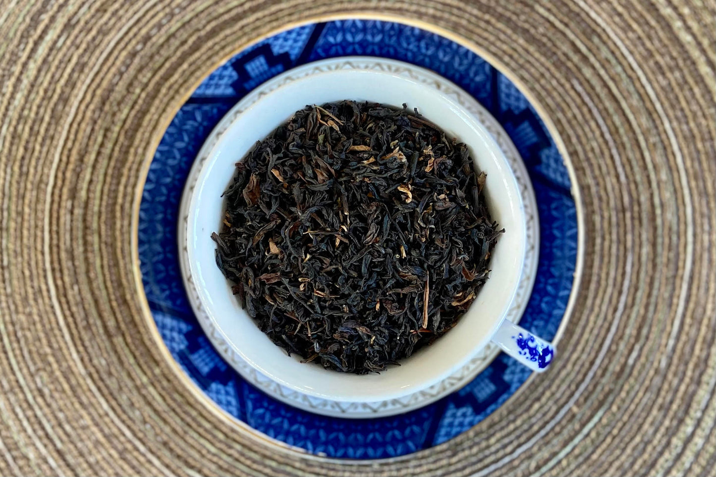 teacup full of black tea with scattered golden tips