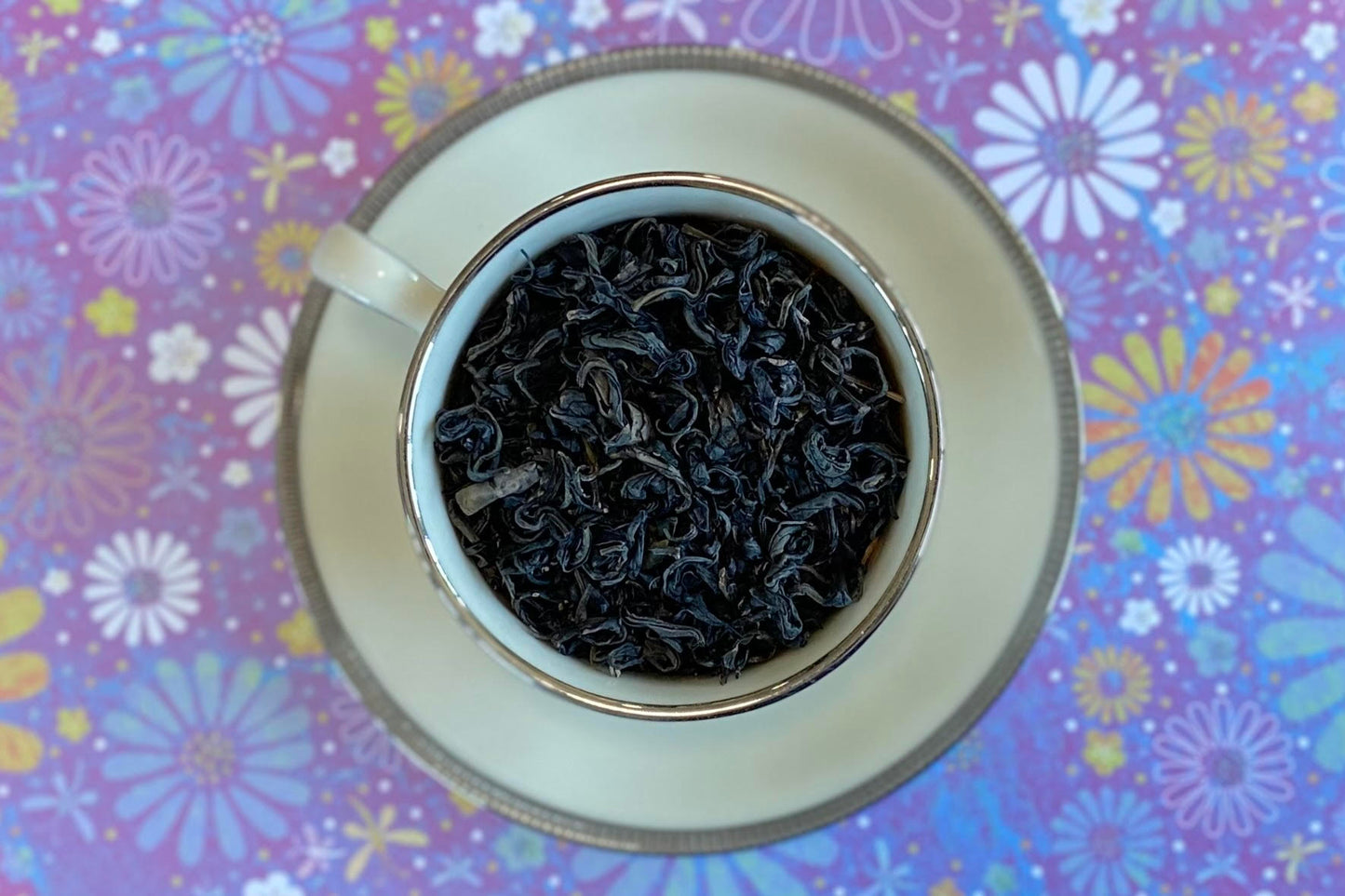 teacup full of purple tipped green tea leaf