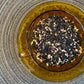 teacup full of black tea with orange and pink botanicals