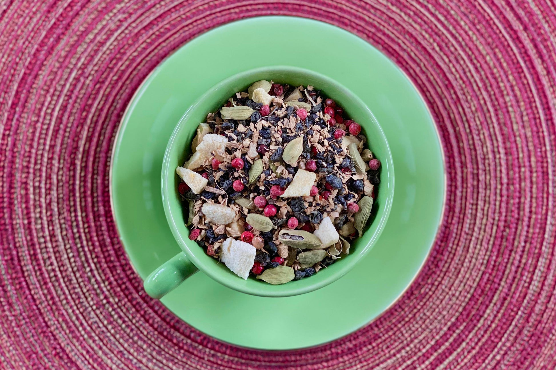 teacup full of green tea, peach, and spices