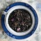 Teacup full of black tea and cherry blossoms 