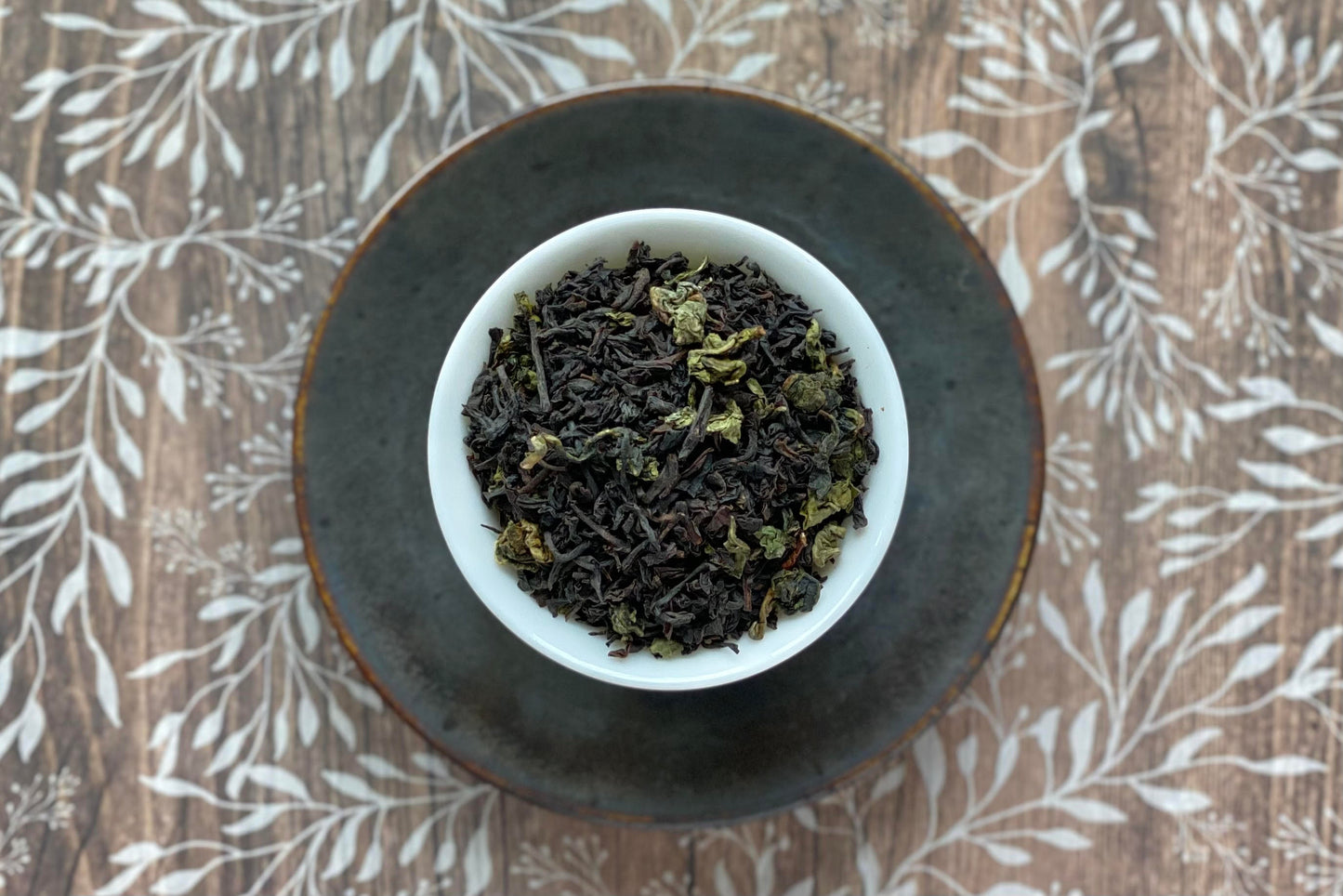 Teacup full of black tea blended with rolled green oolong