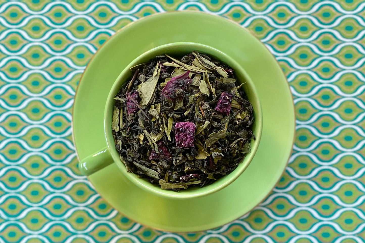 Teacup full of green tea and purple dragonfruit