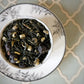 teacup full of green tea and blueberries