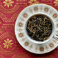 teacup full of large half-black, half-gold tea leaves