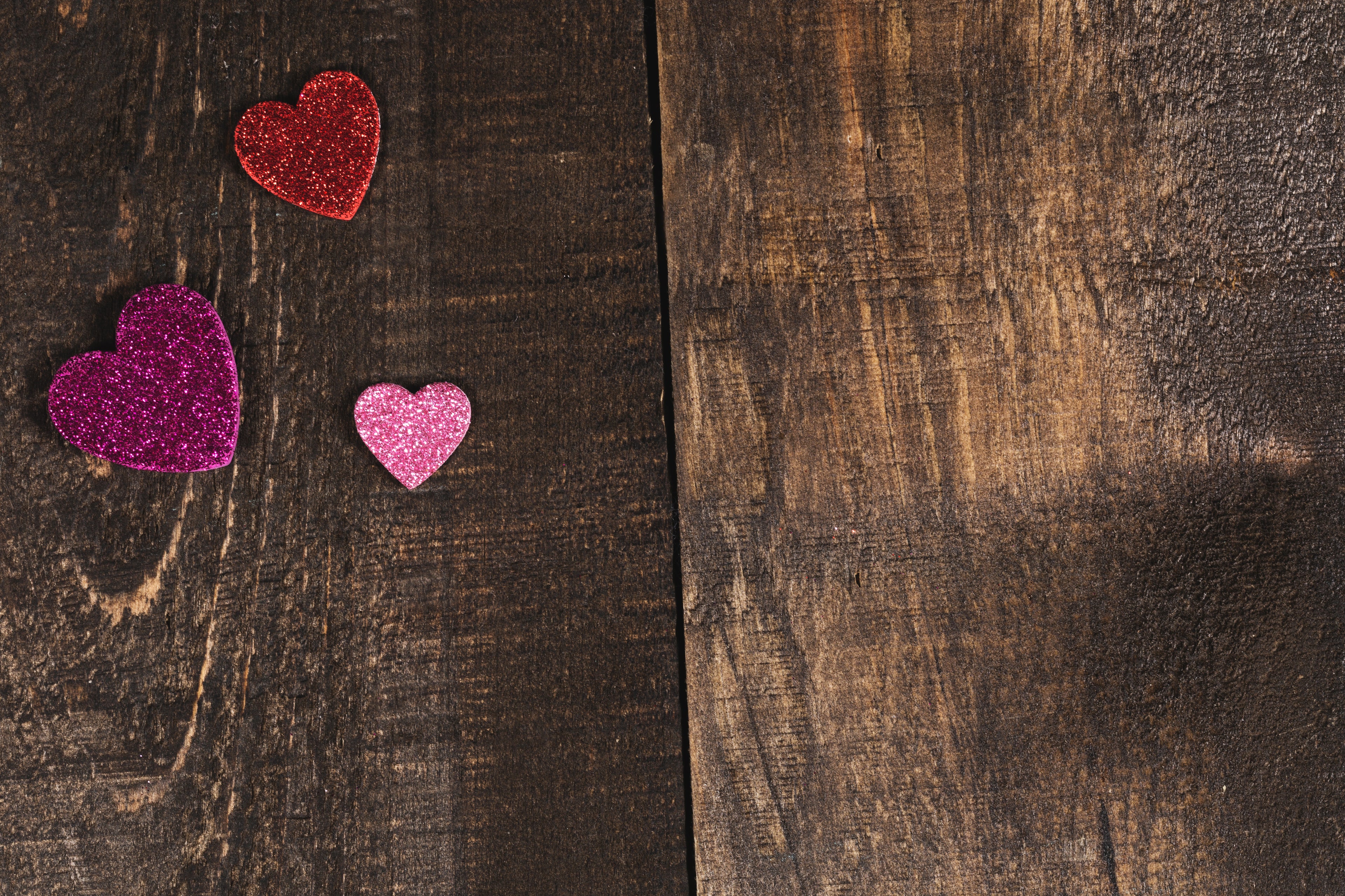 woodgrain background with glitter hearts