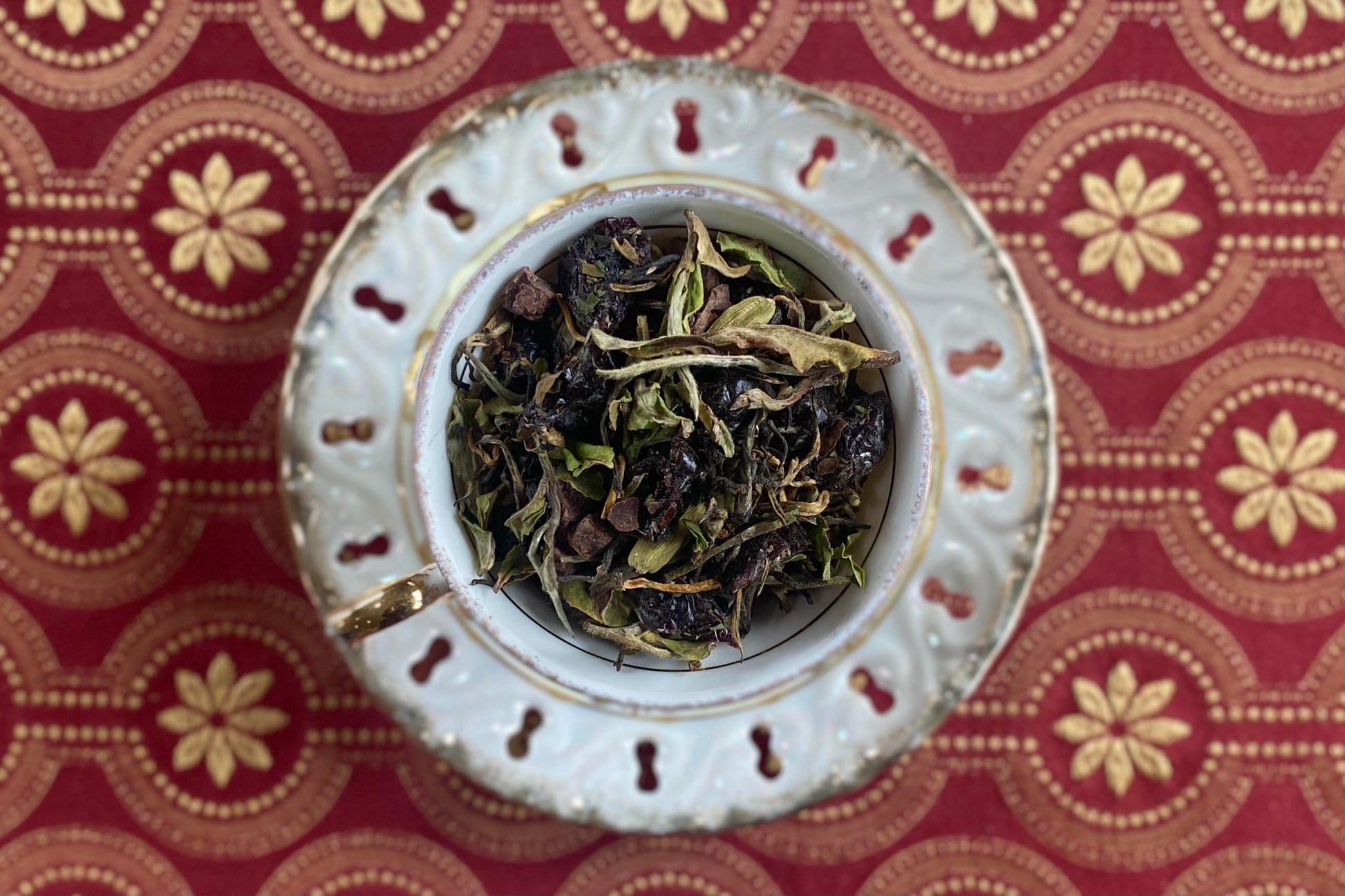 teacup full of white tea with cherries and chocolate