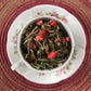 teacup full of white tea and strawberry pieces