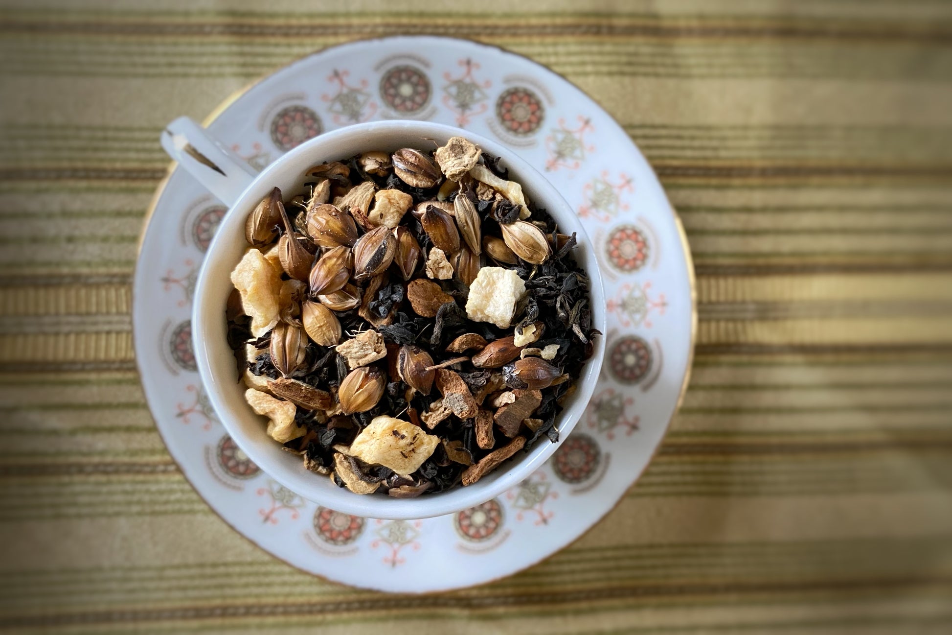 Teacup full of black tea, apple, barley and spices